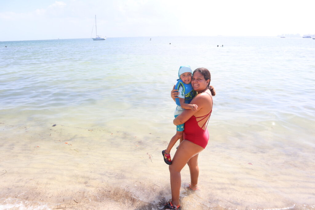 The Travel Mama and her son near the shore of the beach